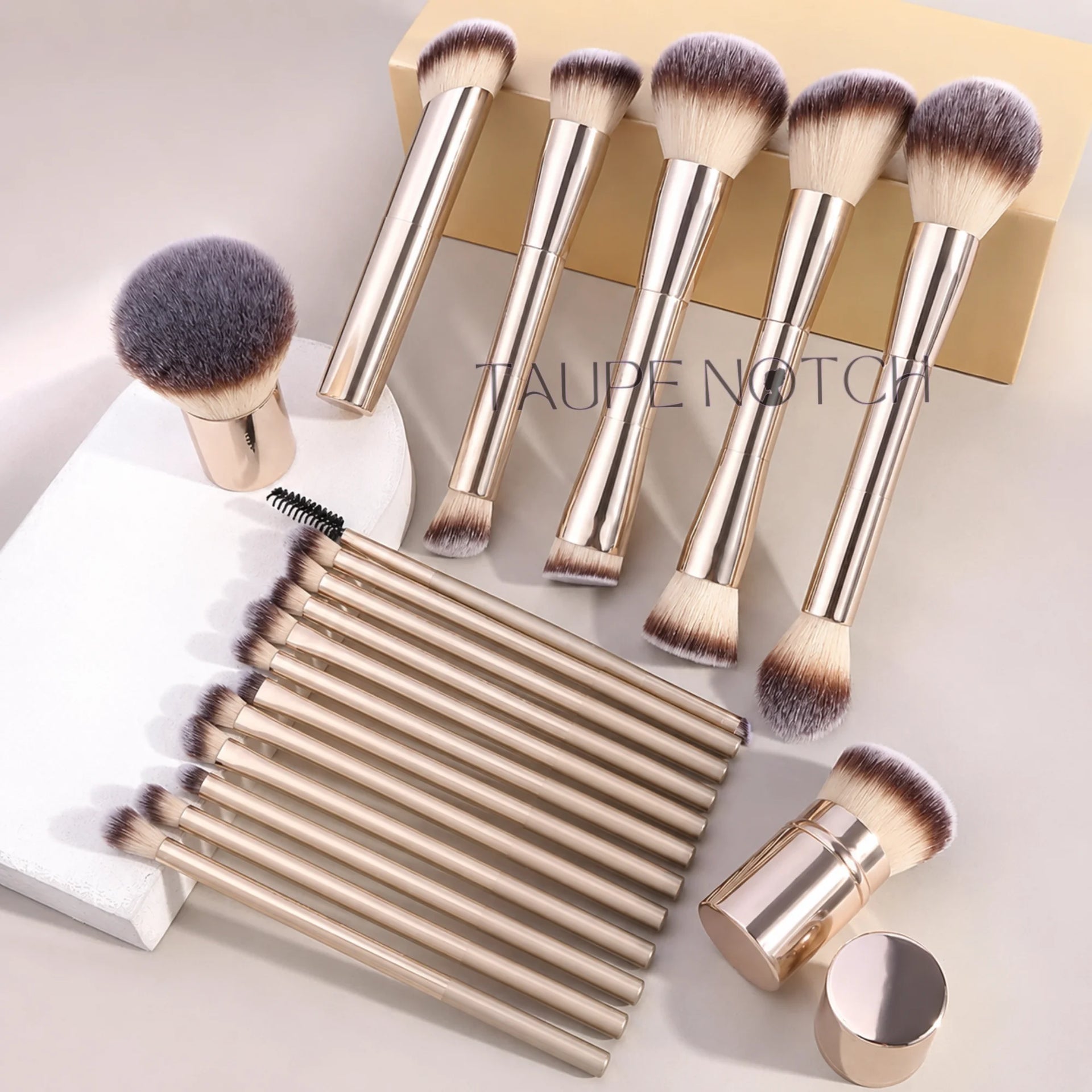 Makeup brush set with metallic gold aluminum handles and soft purple bristles, multiple brush heads.