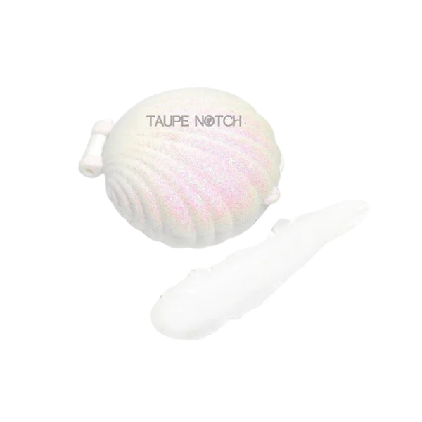 Seashell-shaped sheer lip balm with iridescent pastel pink finish, coconut scent