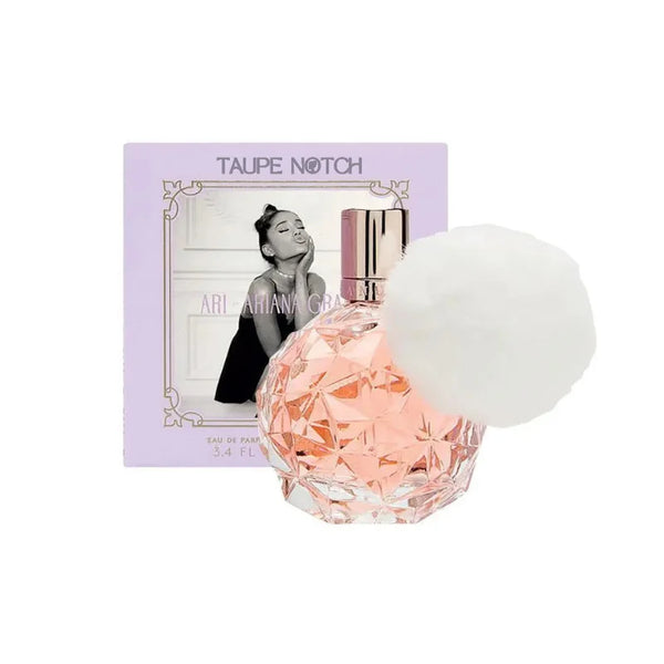 Faceted pink-tinted glass perfume bottle with gold cap and purple box