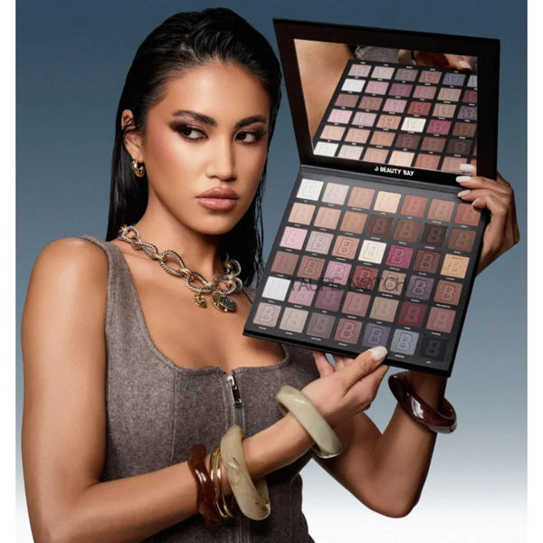 Neutral 42-pan eyeshadow palette held open, showing rows of nude, rose, and brown pans