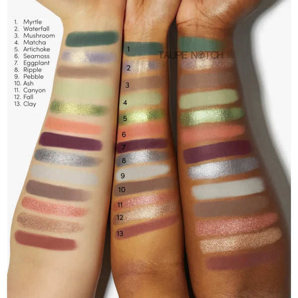 Hand swatches of shimmery eyeshadow shades in green, peach, plum, and gold tones
