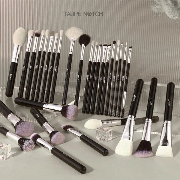Makeup brush set arranged in rows, with soft white bristles and black handles