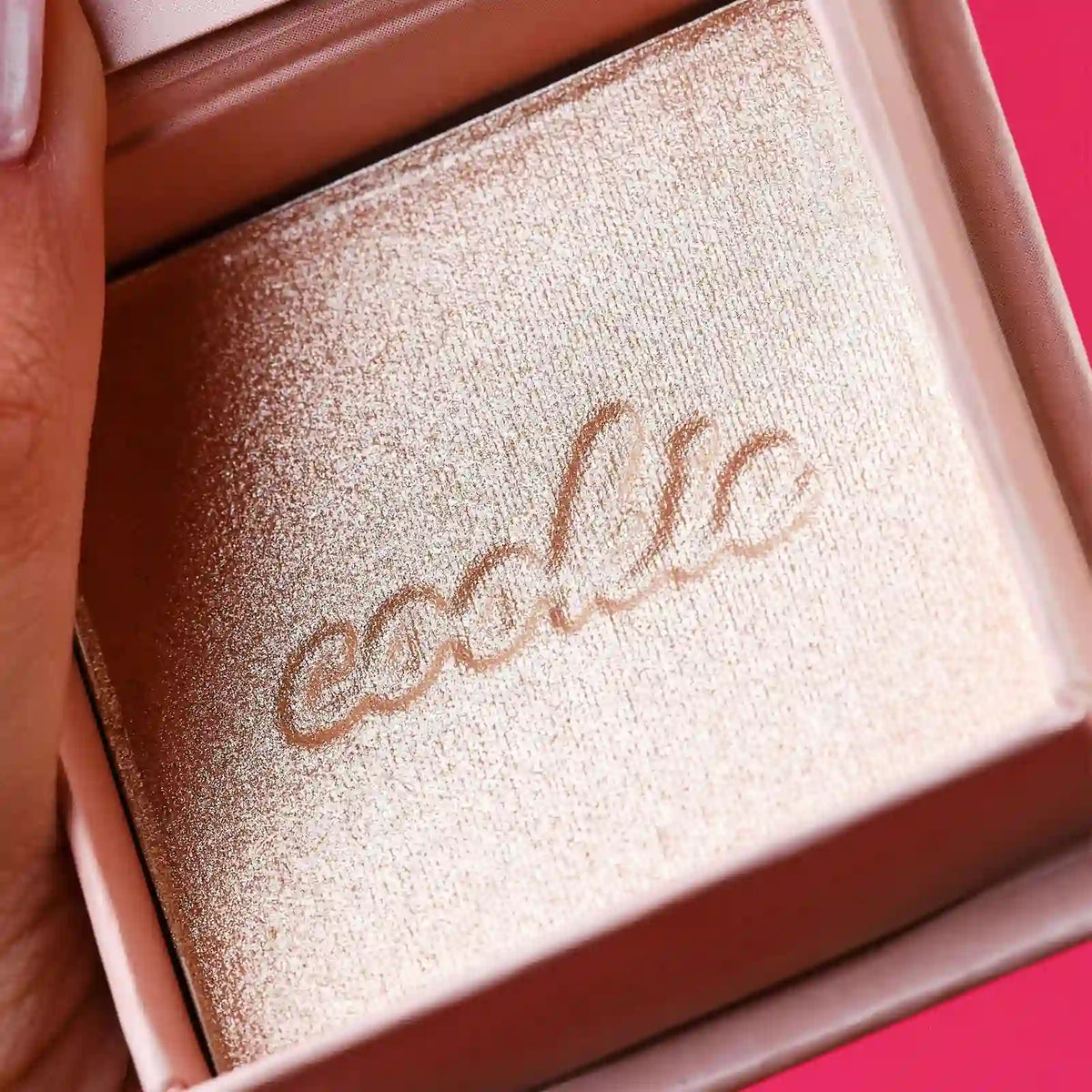Golden pearl powder highlighter pan in compact with “cookie” branding