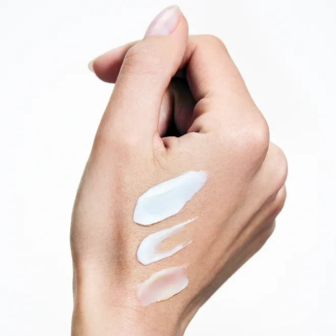 Hand with smooth white cream swatches