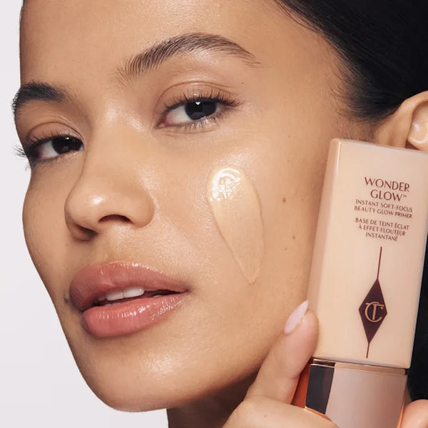 Charlotte Tilbury WonderGlow face primer tube beside glowing skin