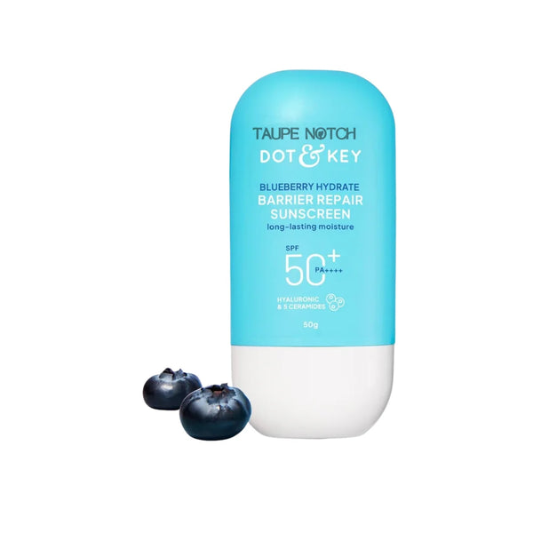 Sunscreen bottle with SPF 50+ label in front of blueberries