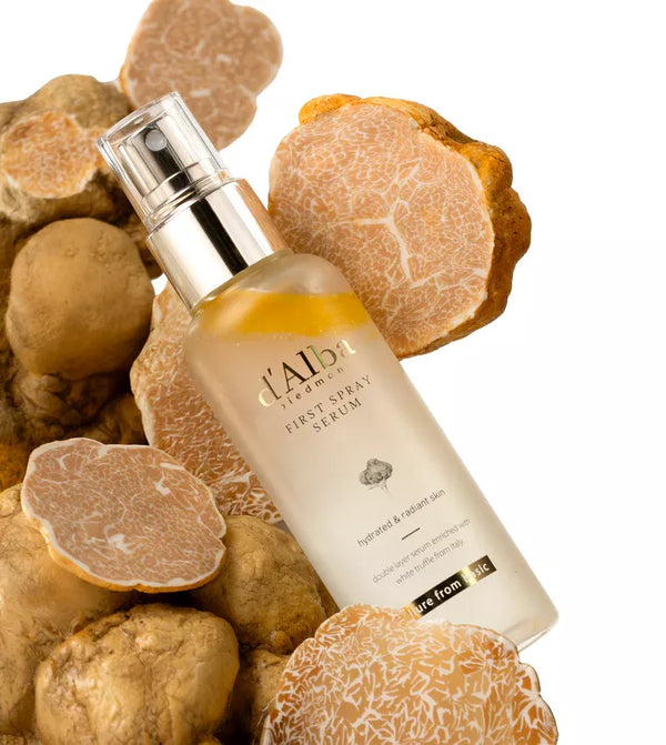 d'Alba First Spray Serum bottle with spray nozzle and golden liquid