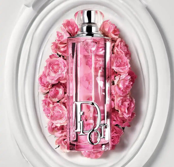 Rosy pink eau de parfum bottle with silver cap, surrounded by pink flowers
