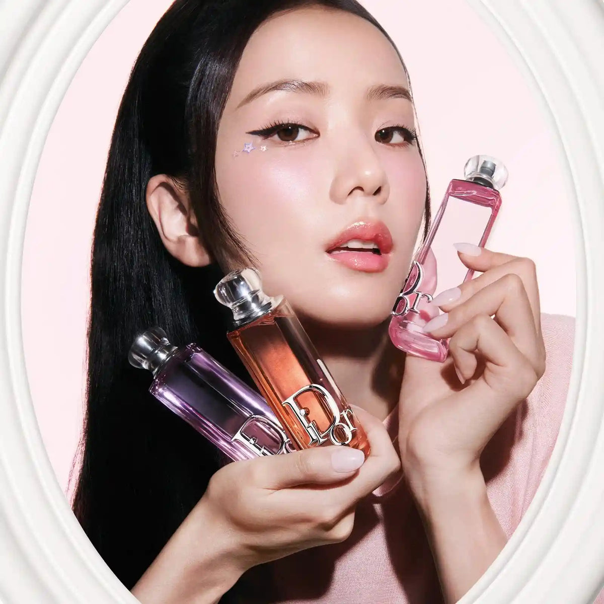 A woman holding Dior Addict Rosy Glow, peachy glow , purple glow Eau de Parfum