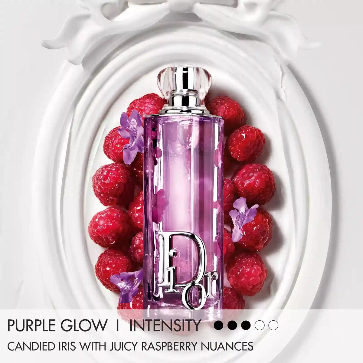 Purple Glow eau de parfum bottle in lilac glass surrounded by red berries