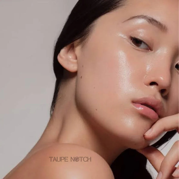 Model with dewy skin glow, hand near face after applying jelly mist