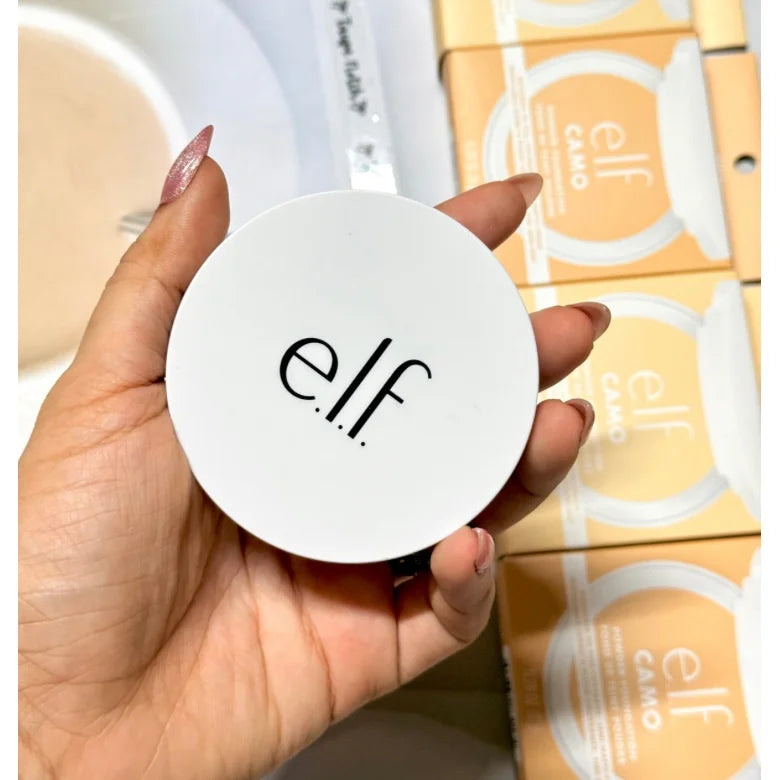 White e.l.f. powder foundation compact lid with e.l.f. logo held in hand
