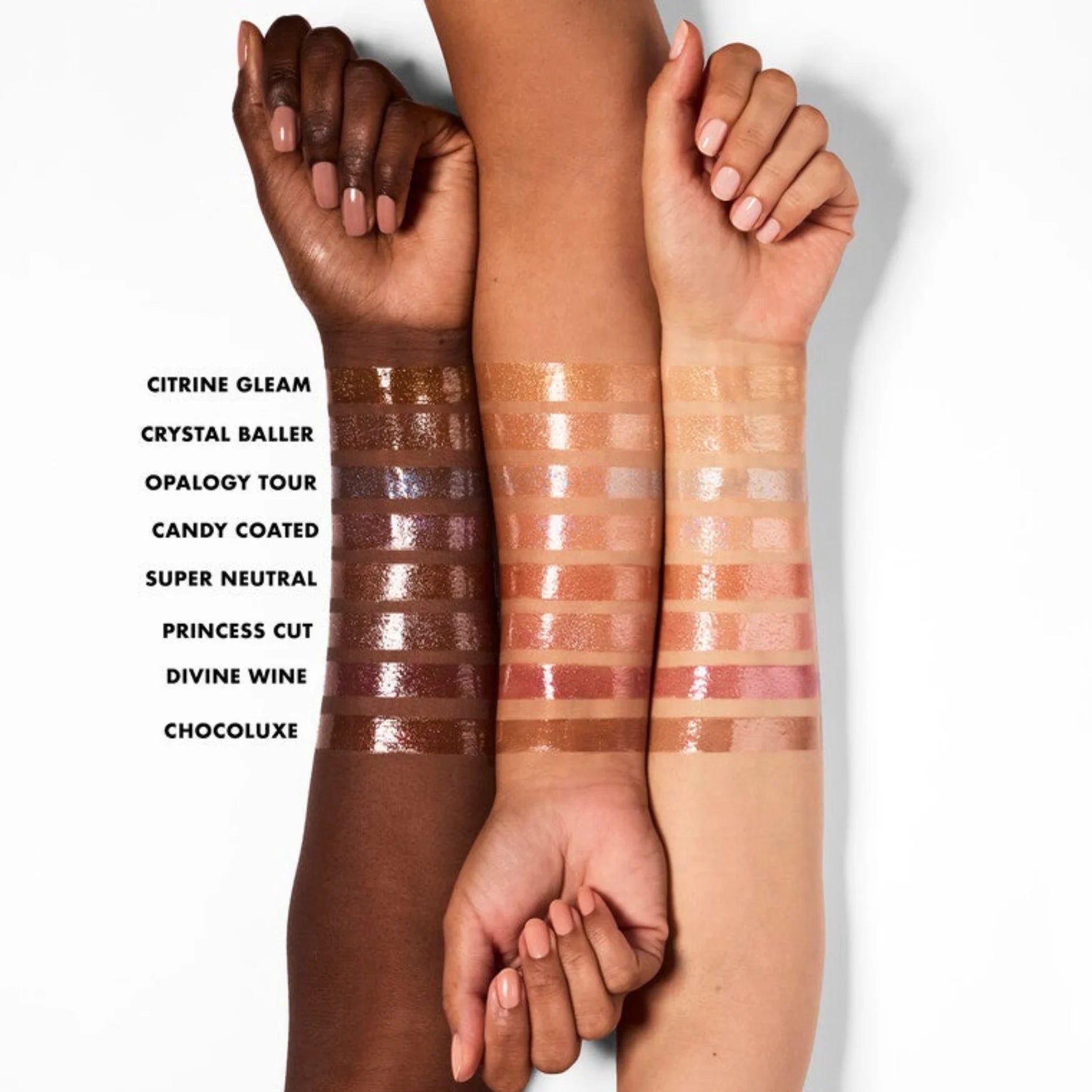 Multiple lip oil shimmer shades swatched on skin, from brown to pink and berry