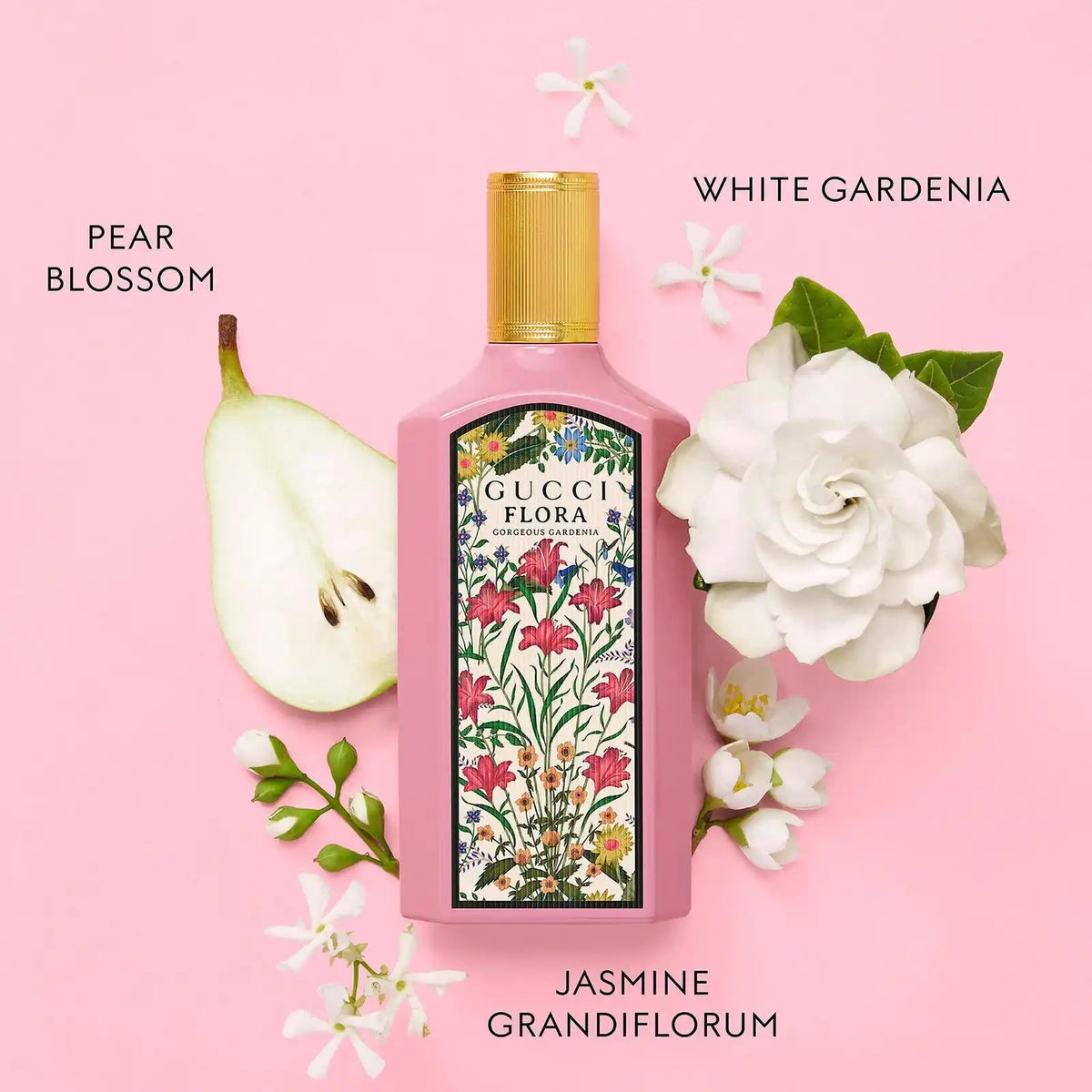 Gucci Flora perfume bottle with pear, white gardenia, and jasmine on a pink background