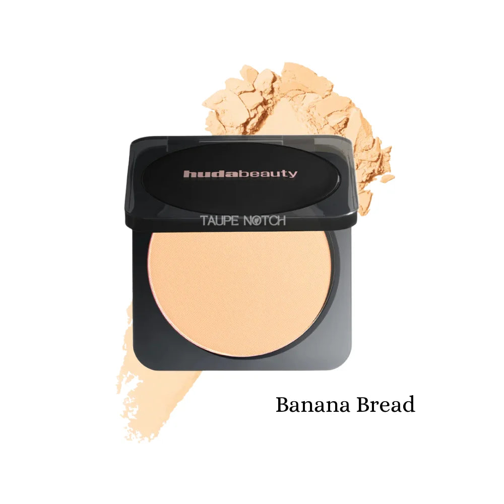 Pressed powder compact with warm yellow-beige shade; black lid, oval pan, beige swatch