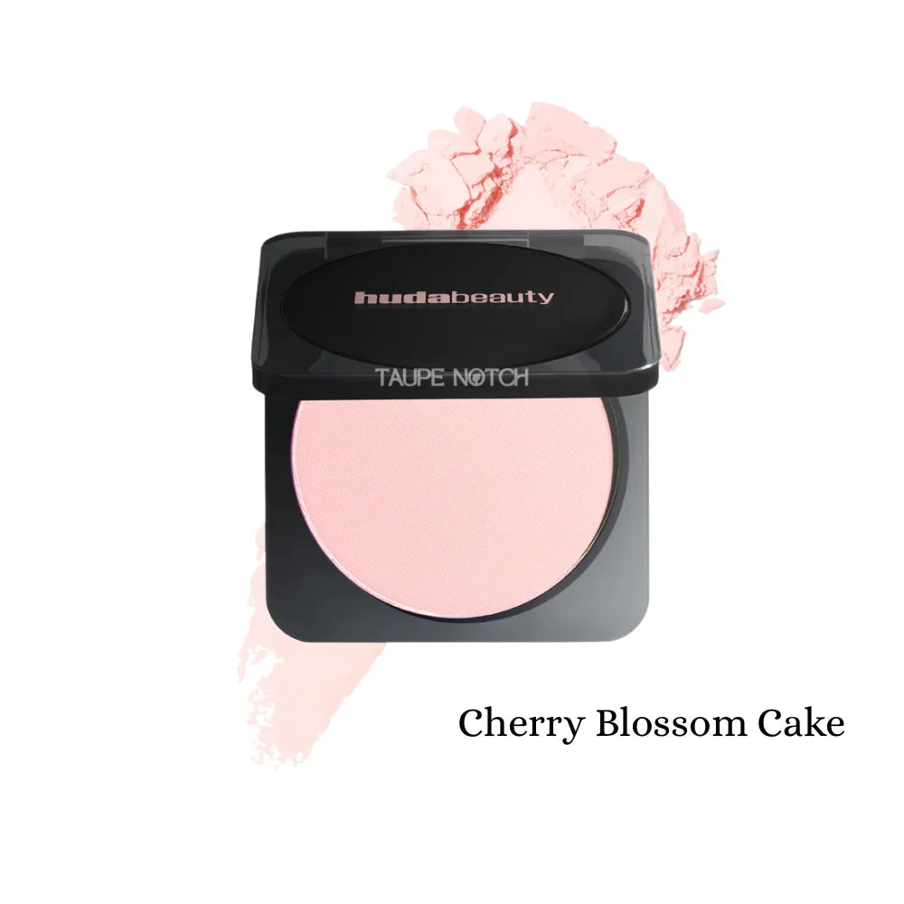 Pressed powder compact with soft pink shade; black lid, oval pan, pink swatch