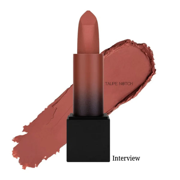 Matte lipstick bullet with terracotta-brown shade on lip swatch, “Interview” label