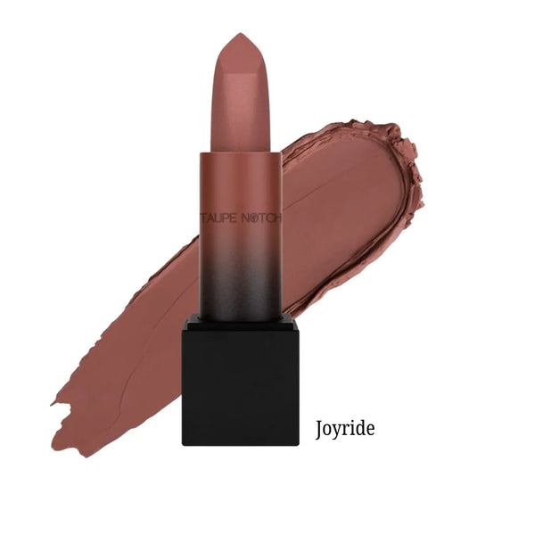 Matte lipstick bullet with cocoa nude-brown shade on lip swatch, “Joyride” label