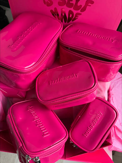 Huda Beauty pink makeup bag set with two glossy zippered pouches and logo