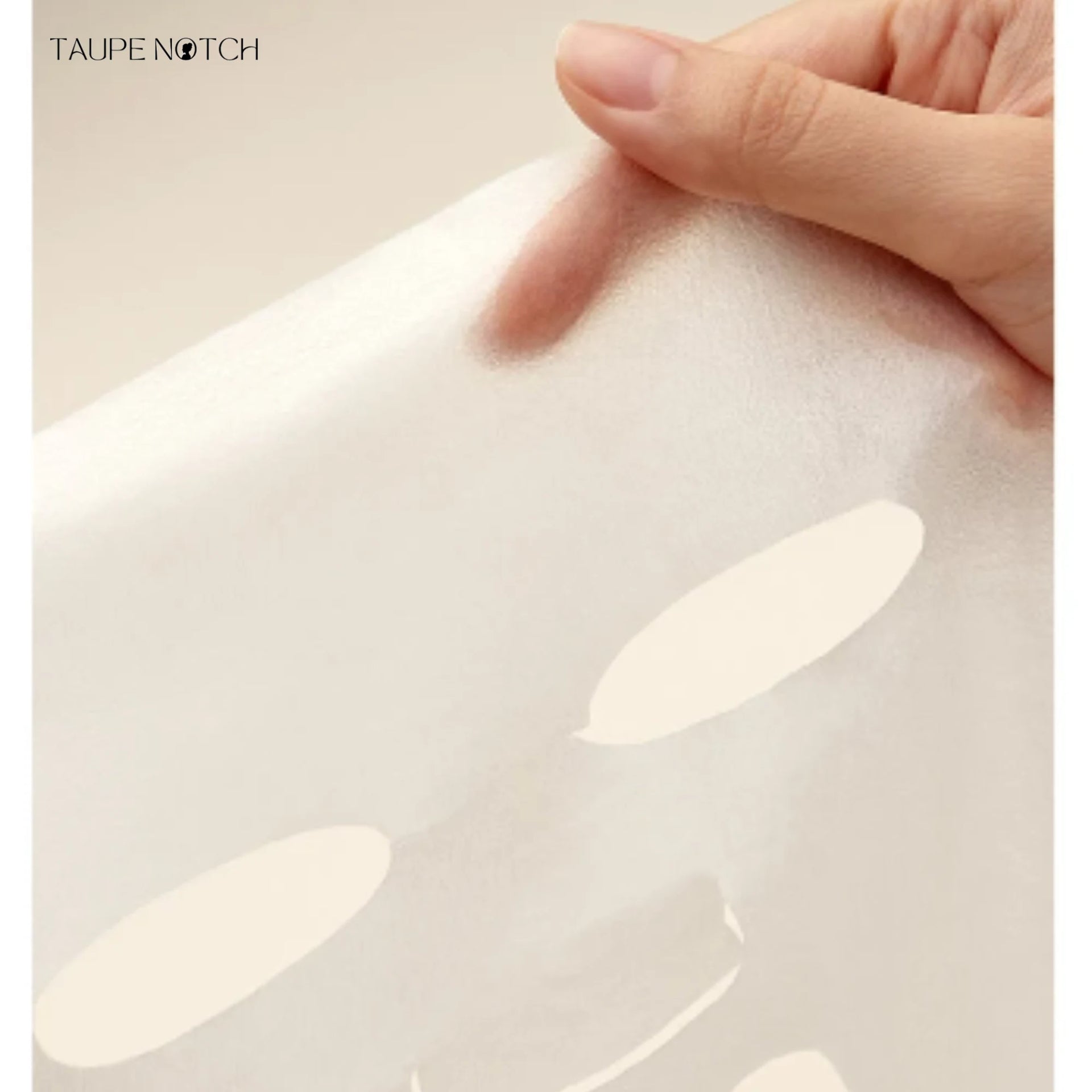 Sheet mask being smoothed onto skin by fingers, pale cream sheet