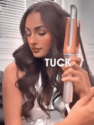 Instant hair curler in use on long dark hair with copper barrel and white handle