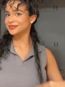 Person using a thermal straightening brush on hair, silver handle with gold teeth