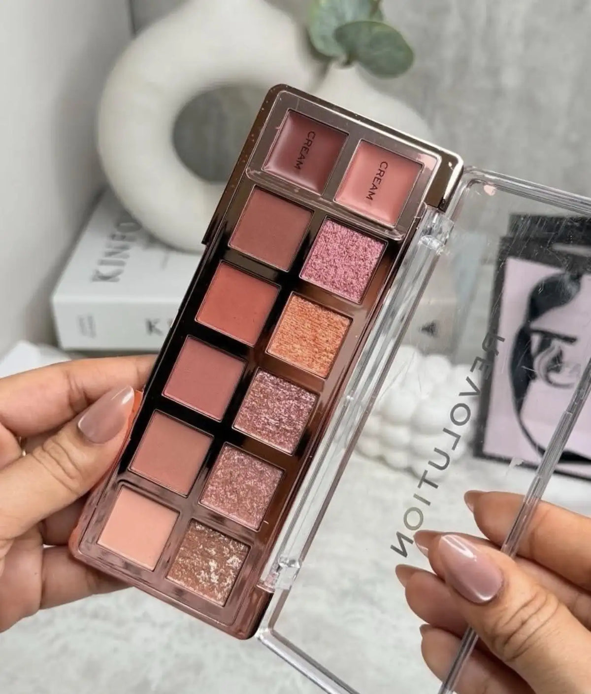 Bronze eyeshadow palette open with warm rose, brown, and glittery shimmer pans