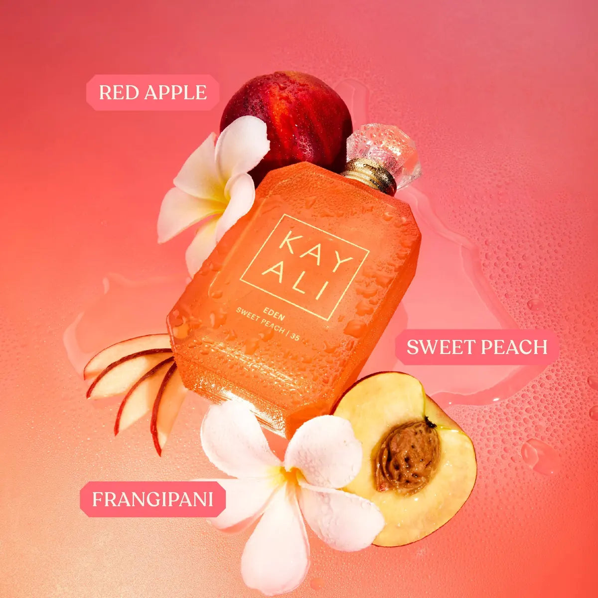 Kayali perfume bottle with red apple, sweet peach, and frangipani elements on a pink background