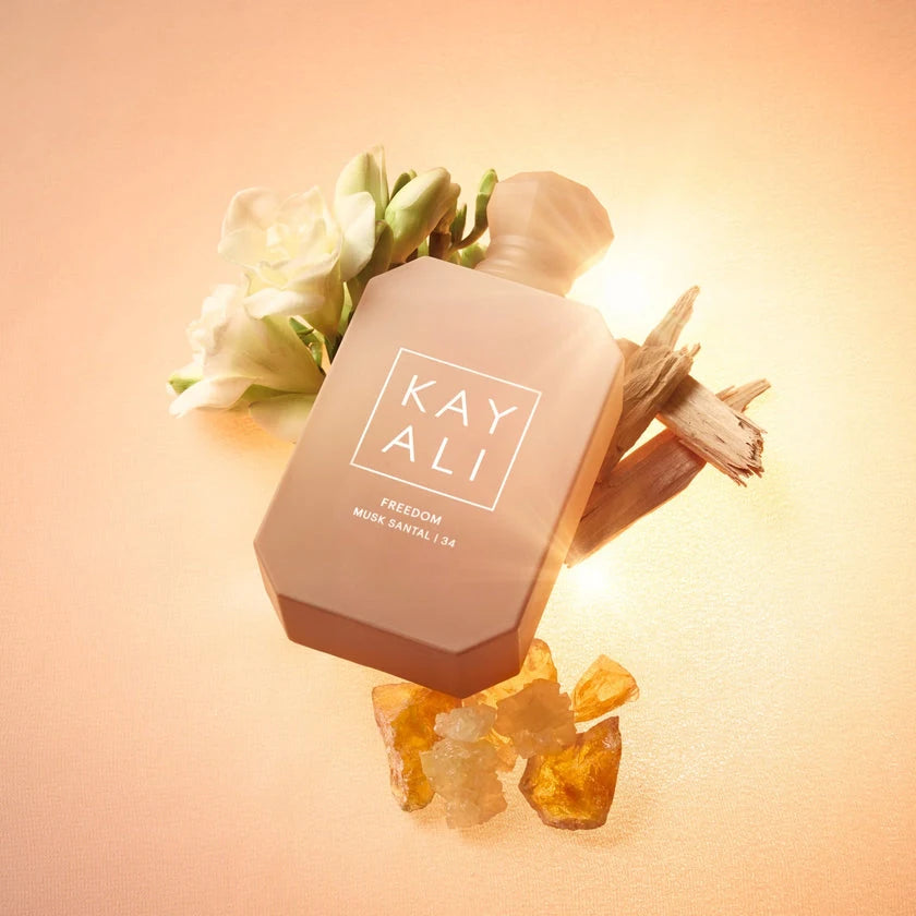 Eau de parfum bottle with white blossoms and light wood pieces