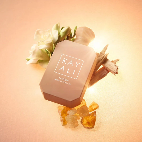 Eau de parfum bottle with white blossoms and light wood pieces