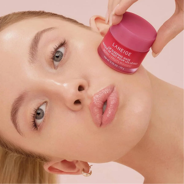 Laneige lip sleeping mask jar held near lips, pink-berry shade