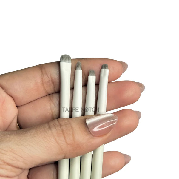Eye brush set held in hand, four small detail brushes with taupe bristles