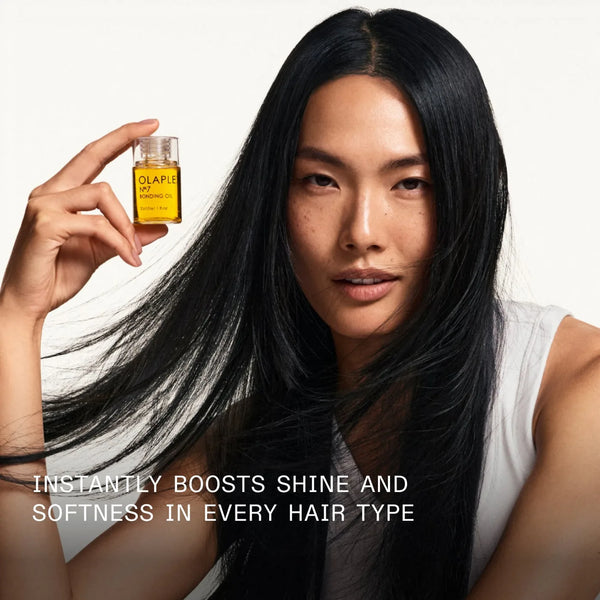 Bonding Oil bottle held beside long black hair
