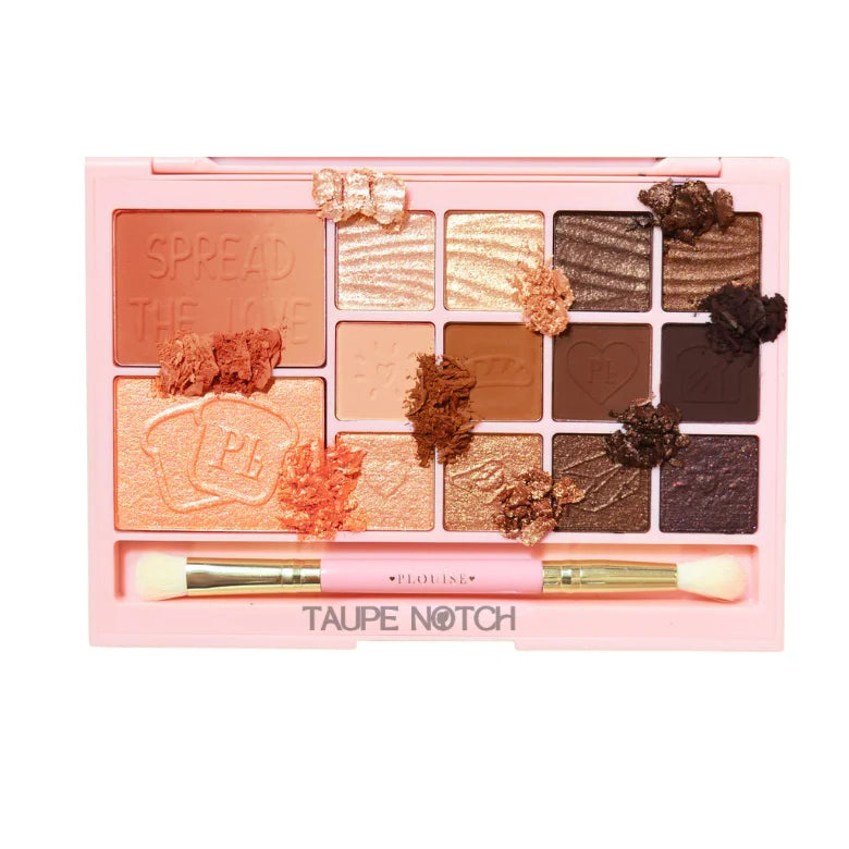 Makeup palette with warm eyeshadow pans and two applicator brushes, taupe-brown shades