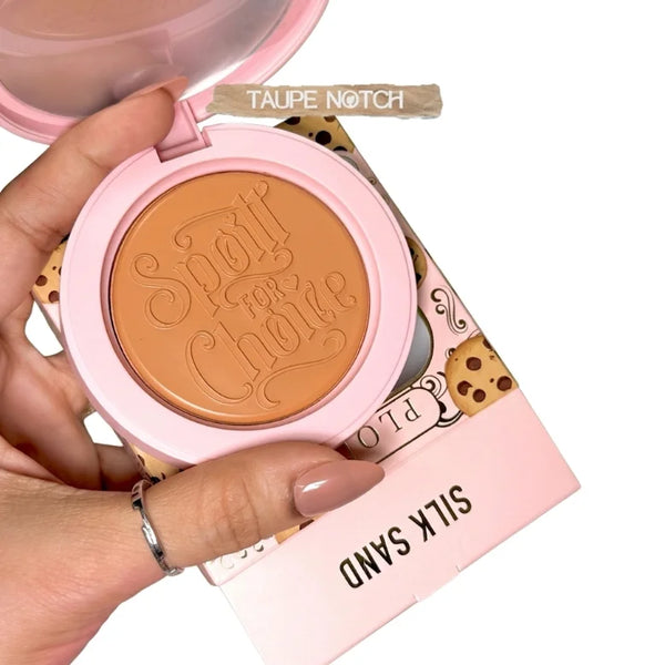 Cream bronzer compact showing embossed taupe-brown pan with pink lid