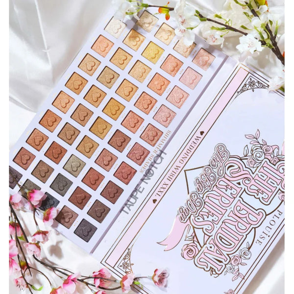 Makeup palette open showing square pans in nude, gold, bronze, and deep brown shades