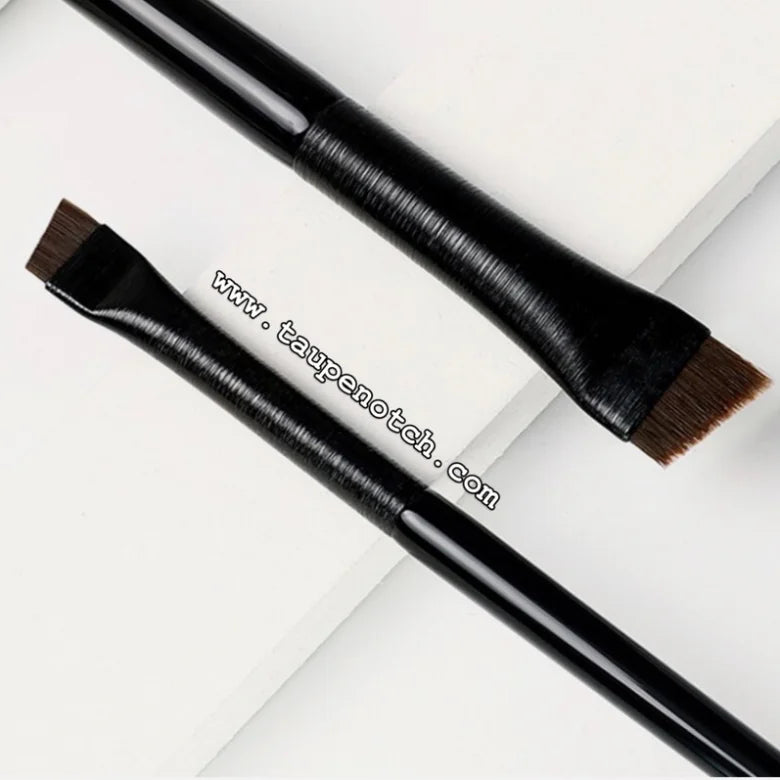 Eyebrow and eyeliner brushes with dark handles and angled brown bristles, angled view