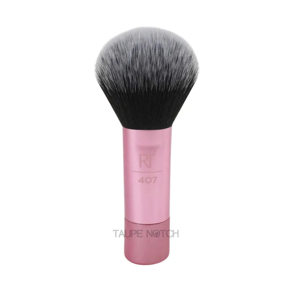 Multitask makeup brush head with dense black bristles on rose-pink handle