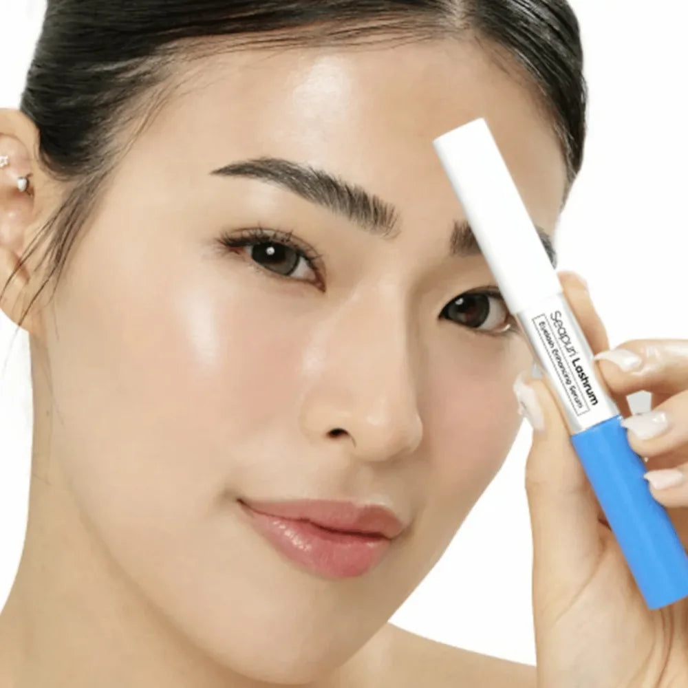 A close-up of a woman holding a blue and white cosmetic eyebrow pencil against a clean white background.