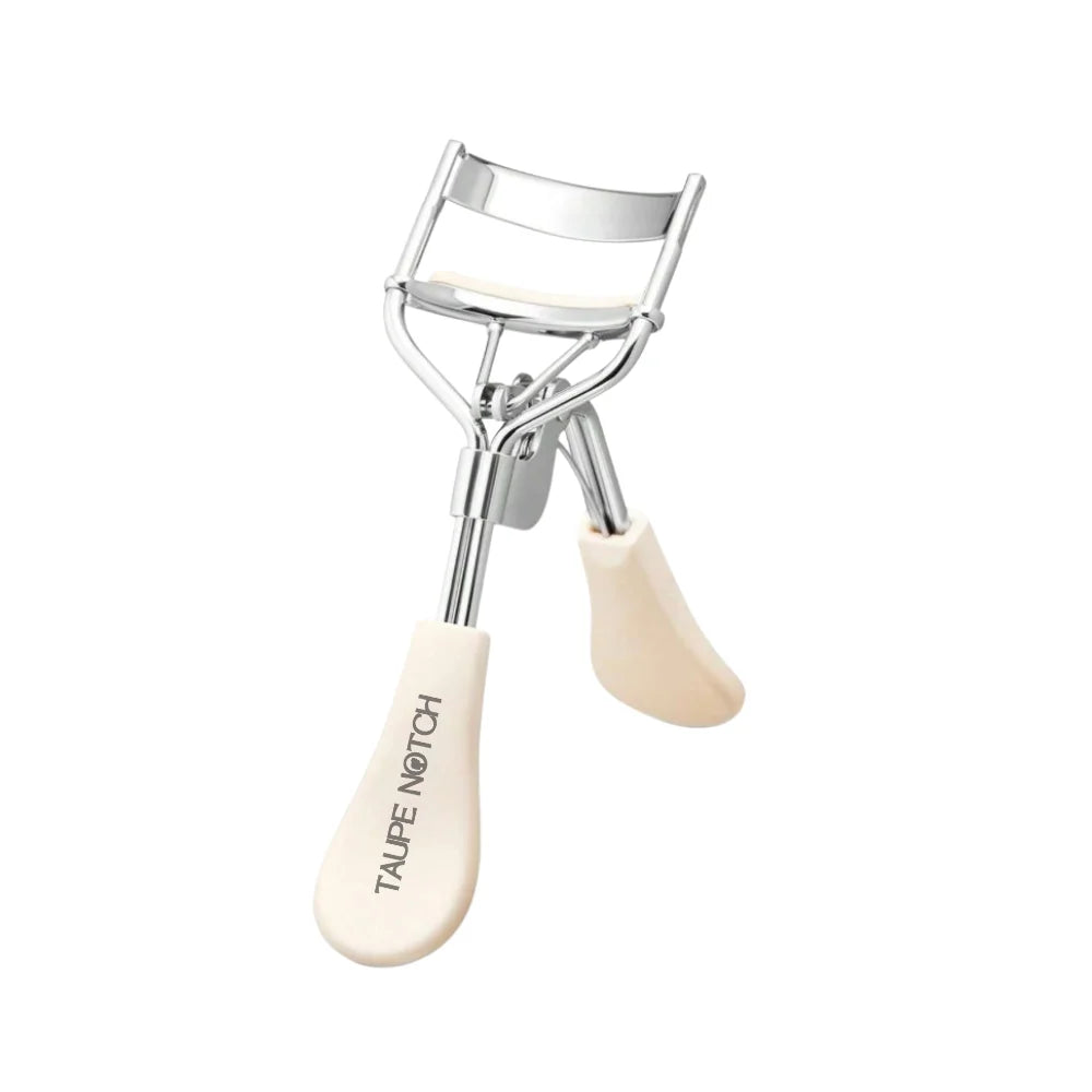 Eyelash curler with beige grip and silver metal clamp