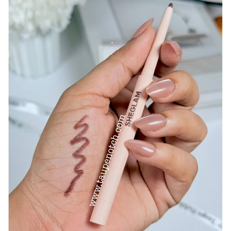 Taupe-brown lip liner pencil held in hand with dark brown swatch line