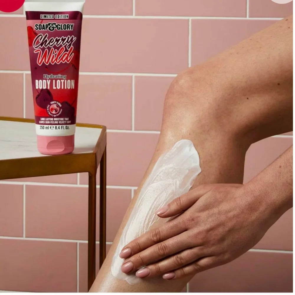 Hand applying body lotion with tube beside on skin