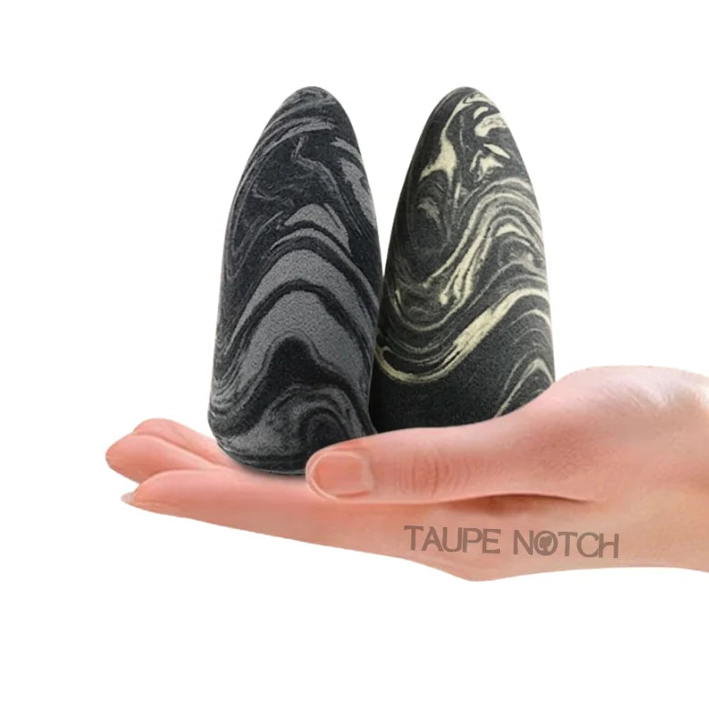 Marble-pattern beauty sponge with tongue shape, gray and black, held in hand