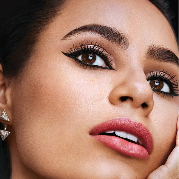Black waterproof liquid eyeliner wing on eye look with lashes and red lipstick