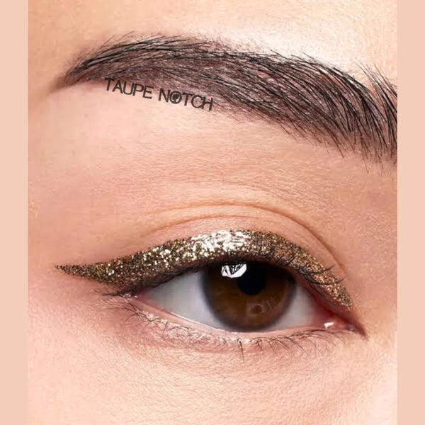 Glitter eyeliner on eye with taupe-bronze shimmer across lid near lash line