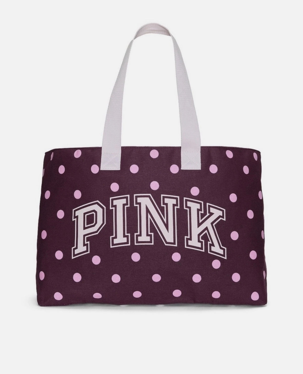 Polka dot canvas tote bag with “PINK” logo and light purple handles, dark plum