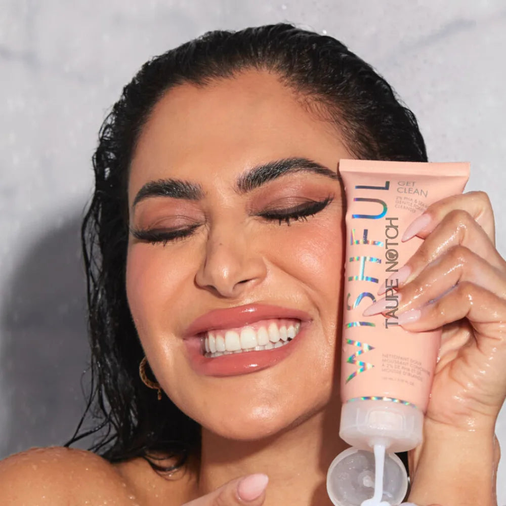 Gentle foaming cleanser tube held in hand, peach-pink label, squeeze nozzle