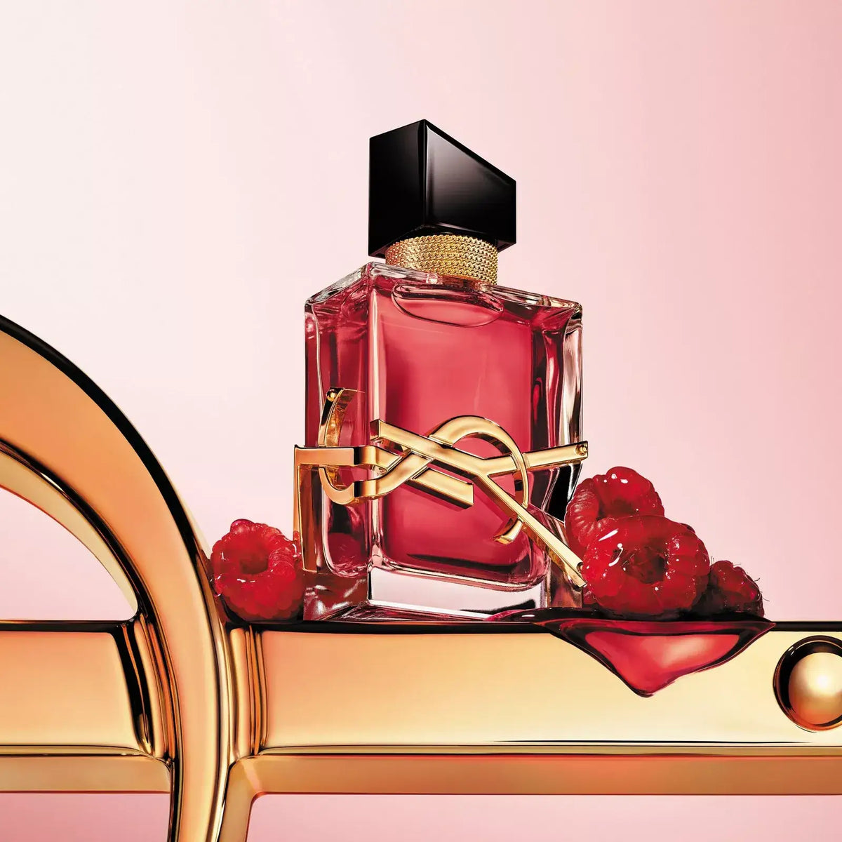 Perfume bottle with raspberries on a pink background